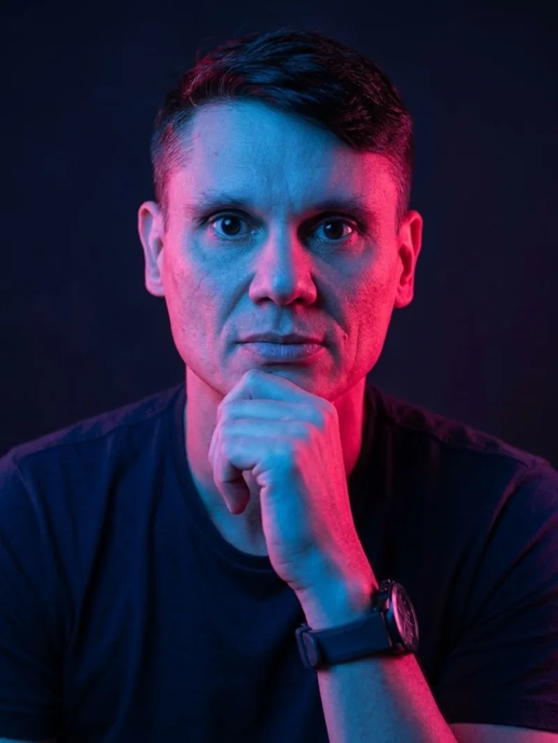 Retrato de Aldo Batista com iluminação vermelha e azul